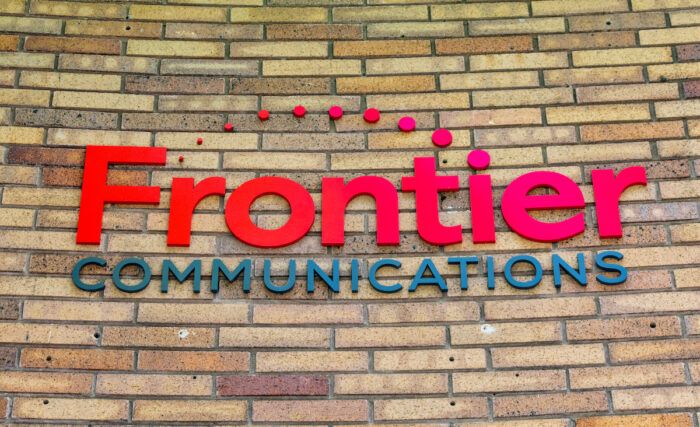 Frontier Communications trademark logo and sign on the office of telecommunications company.
