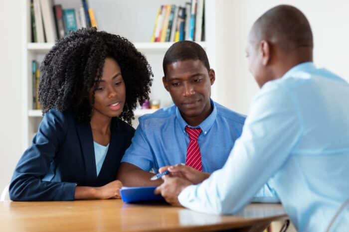 Real estate agent talking about new house with african american couple at office of company