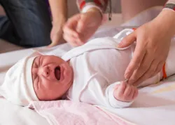 Newborn baby crying on the bed, selective focus