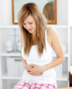 Cute woman having a stomachache in the bathroom