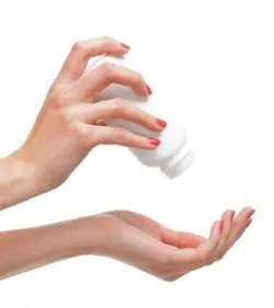 Beautiful female hands with the talcum powder isolated on white