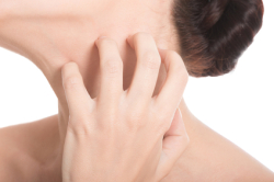 Young beautiful topless woman is scratching her neck.