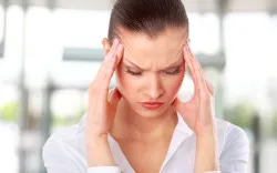 Young woman suffering a headache over white background