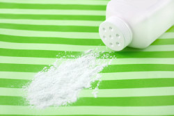 Spilled baby scented powder on striped green background with short depth of field