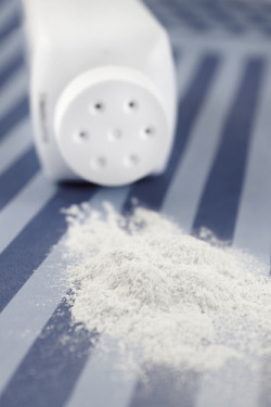 Spilled baby scented powder on striped background