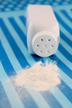 Spilled baby scented powder on striped background with short depth of field