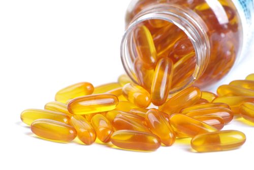Fish oil capsule and container on a white background