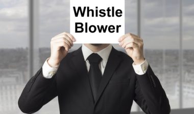 man holding whistleblower sign