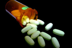 Prescribed antibiotic tablets falling out of its bottle. - Zithromax