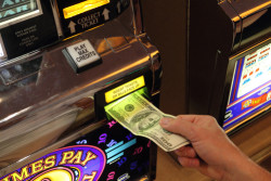 hand putting money into slot machine in Las Vegas - USA