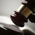 Juridical concept with hammer and lawbook, selective focus on metal part,toned f/x