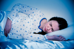 asian caucasian woman with pain in her stomcah