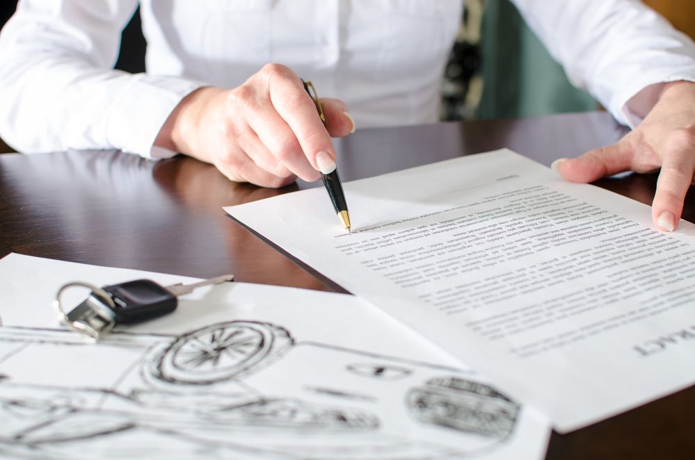 Woman reading a car purchase contract in car dealership