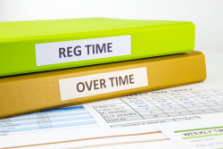 Regular time and Over time words on labels, document binders place on employee time sheets