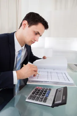 Businessman Holding Calculating Expense In Office