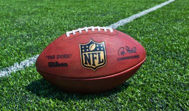NFL branded football on a grass field played by the Rams team