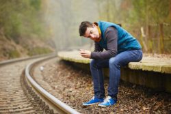 Sad young man at the railway station