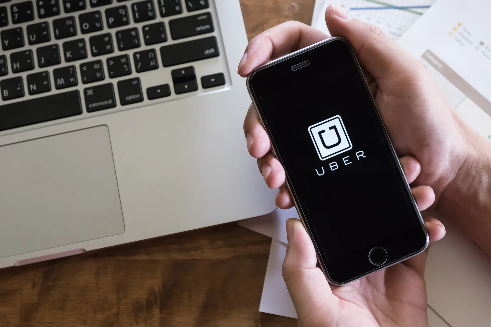 CHIANG MAI,THAILAND - AUG 2,2016 : A man hand holding Uber app showing on iPhone 6S, Uber is smartphone app-based transportation network.