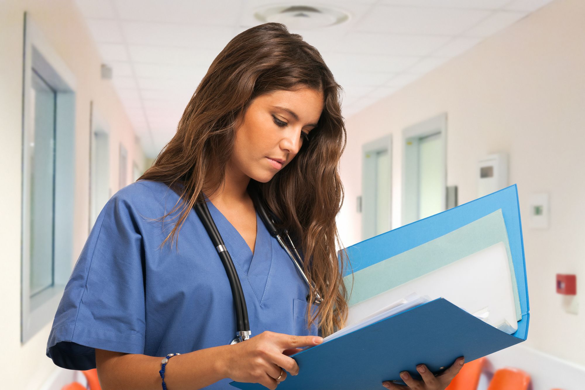 Portrait of a young nurse reading a document in an hospital