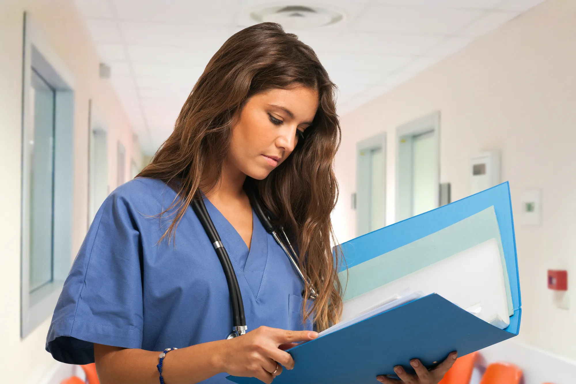 Portrait of a young nurse reading a document in an hospital