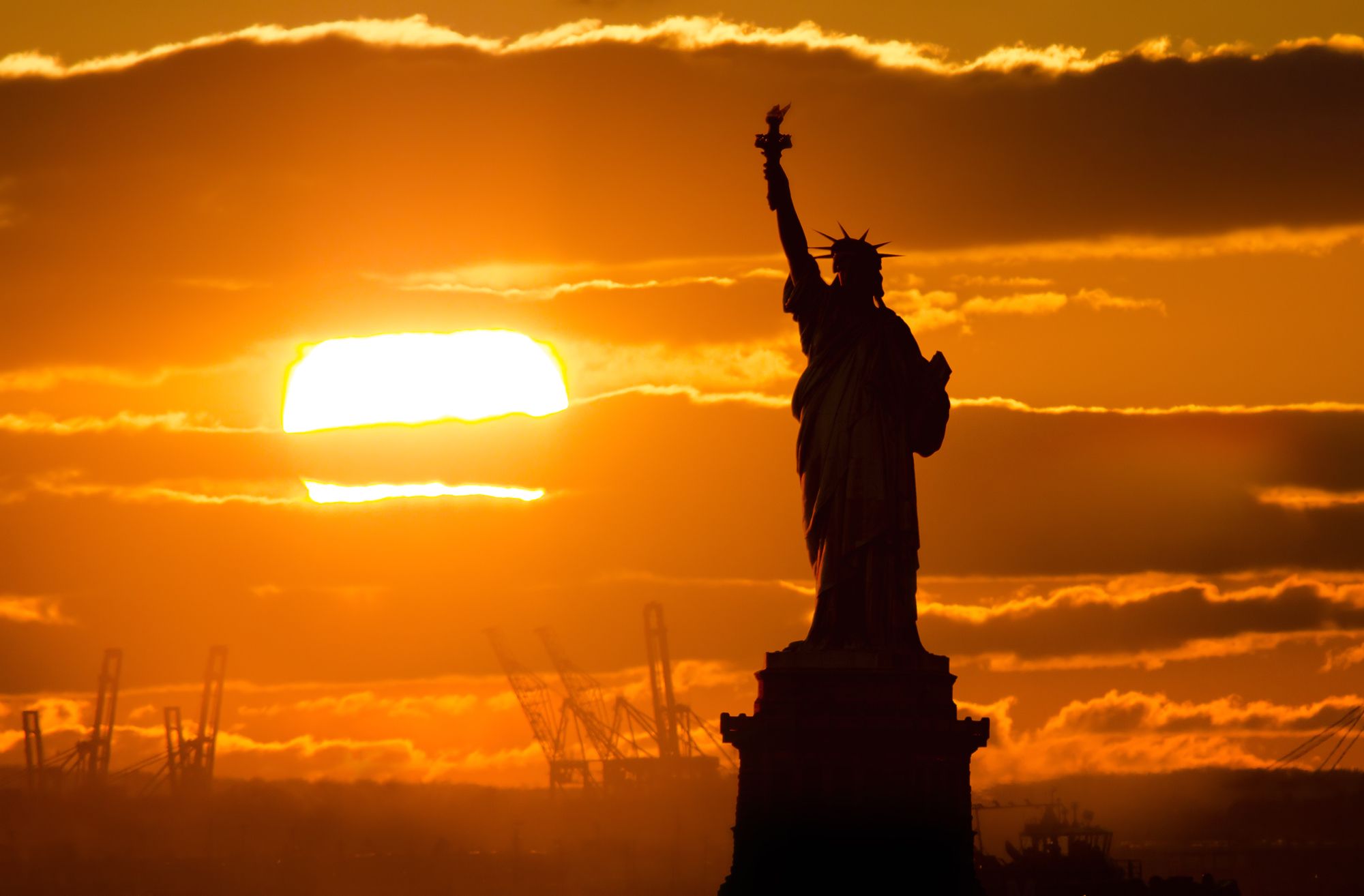 Photo of the Statue of liberty in sunset fire made from Brooklyn, New York City