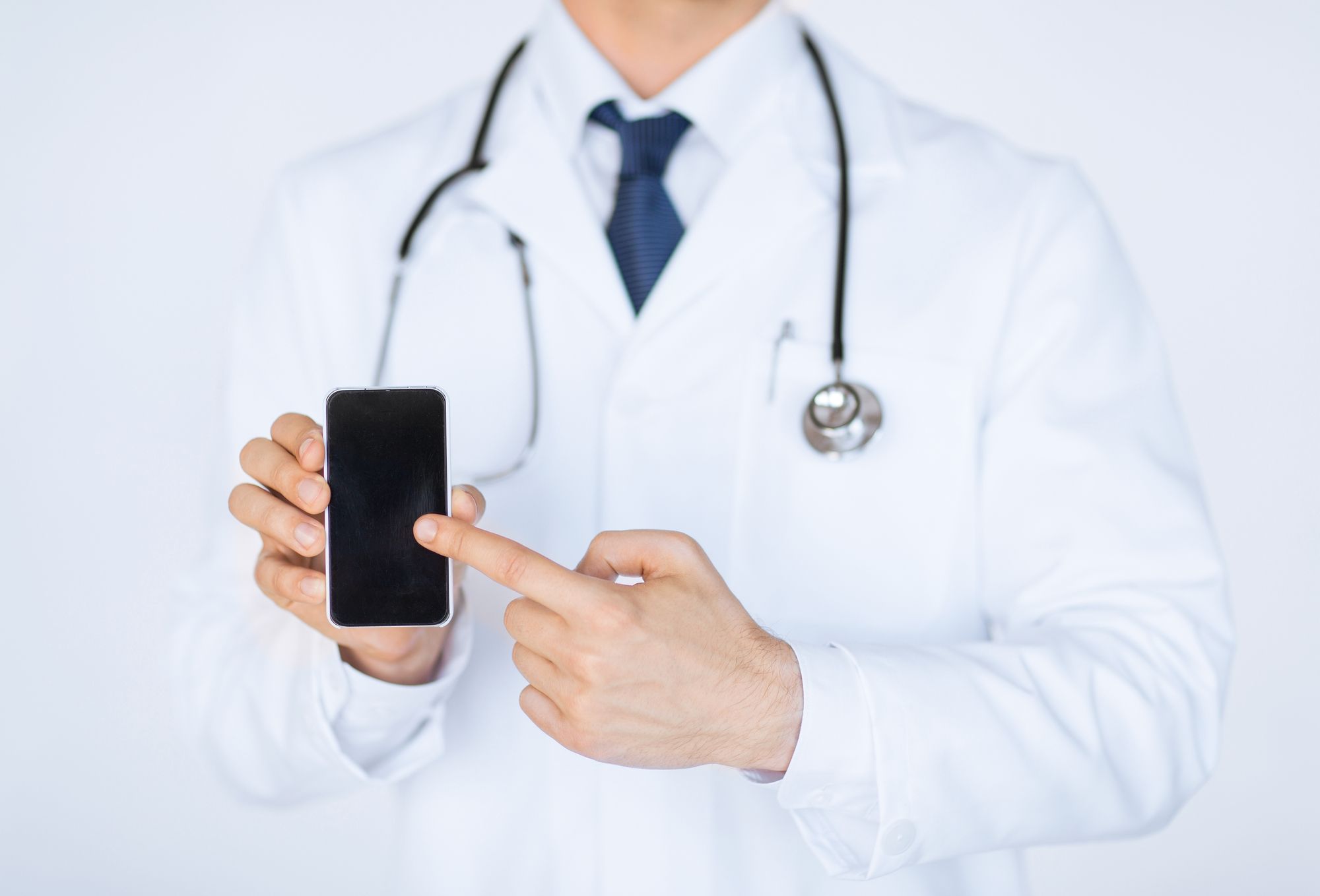 close up of male doctor pointing at smartphone