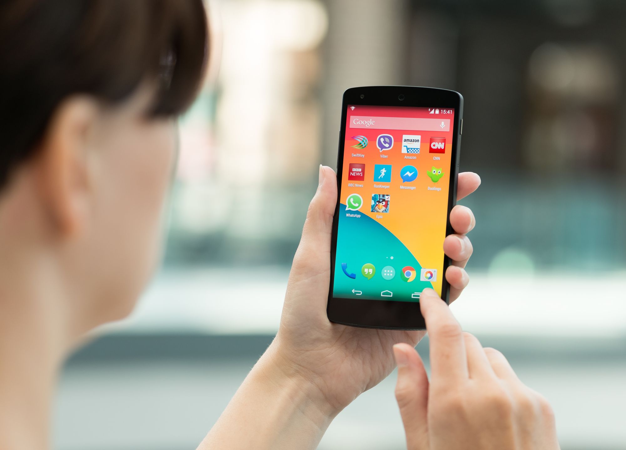 Kiev, Ukraine - September 14, 2014: Woman using a brand new Google Nexus 5 outdoors. Google Nexus 5 is powered by Android 4.4 version, manufactured by LG Electronics.