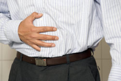 Closeup of a man having stomach pain or indigestion.