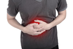 Young man holding his stomachache to this pain.