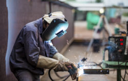 Worker with protective mask welding metal