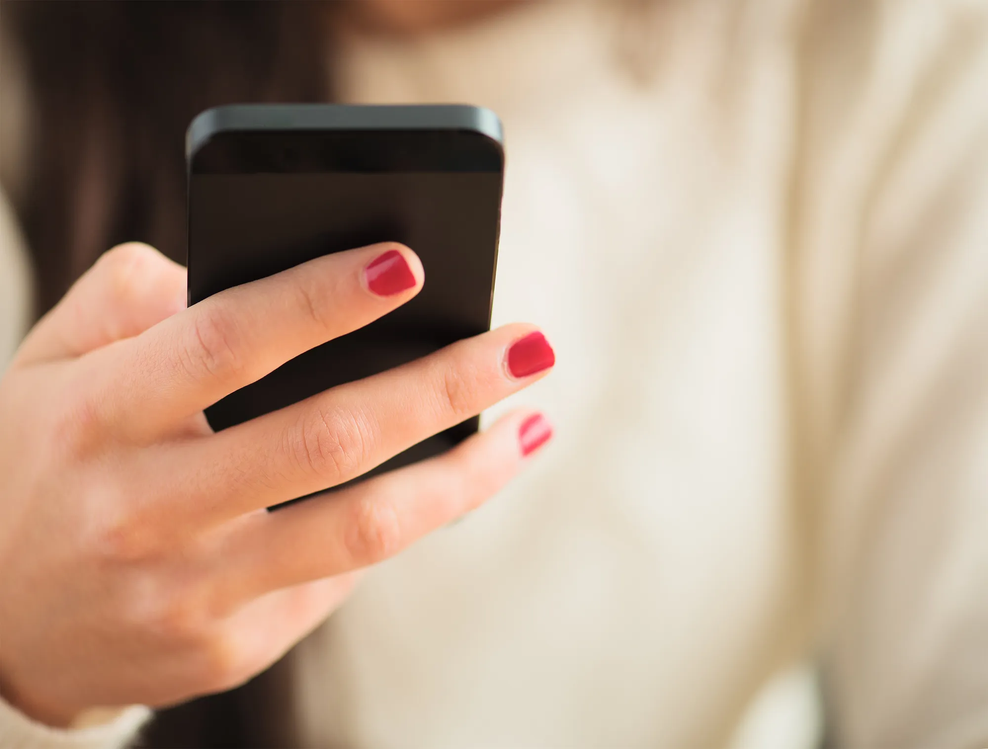 Close-up Of Woman's Hand Using Cell Phone