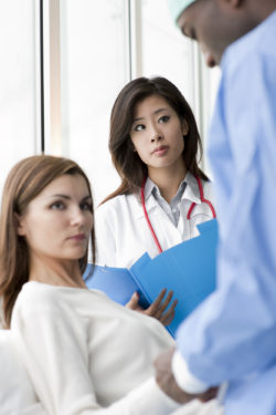 Doctor and surgeon speaking with a female patient