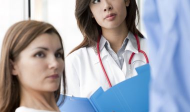 Doctor and surgeon speaking with a female patient