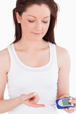Cute woman using a blood glucose meter