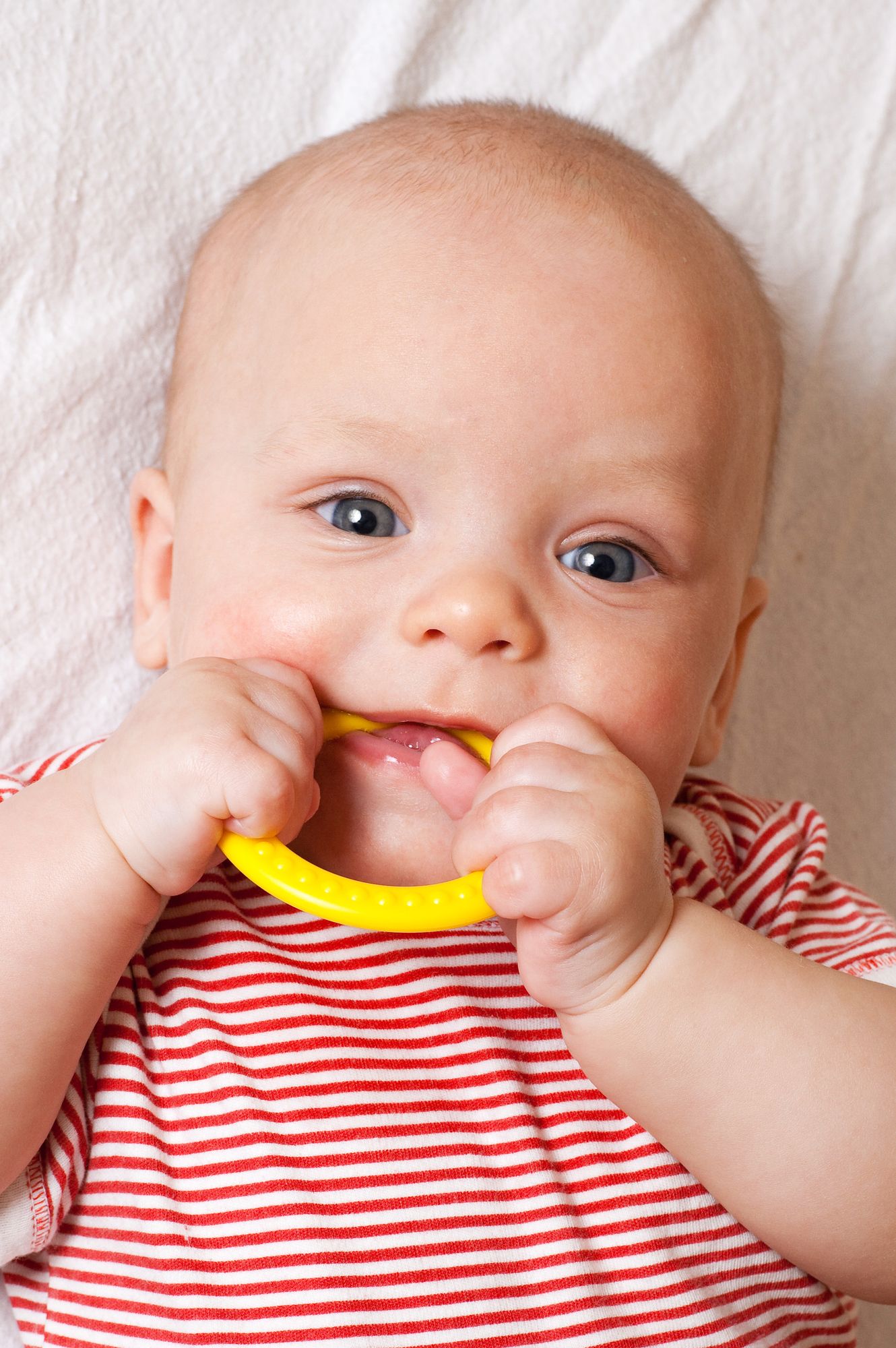 Cute baby with a yellow teething ring