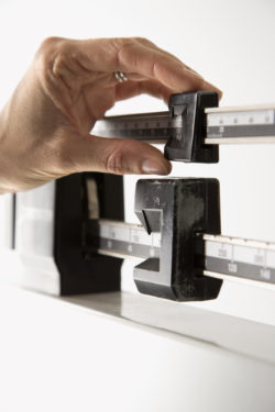 gastric balloons stomach balloon weight loss Hand on weight scale.