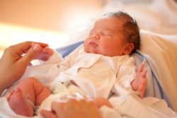 Mother holding she's new born baby's hand