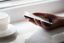 mock up of smart phone and girl holding it over a wooden table
