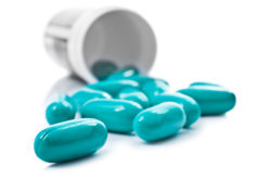 Blue pills an pill bottle on white background