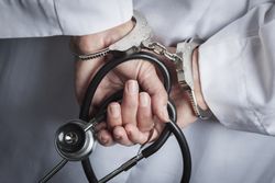 Female Doctor or Nurse In Handcuffs and Lab Coat Holding Stethoscope.