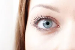 Close-up shot of young woman's blue eyes. Isolated on white background.