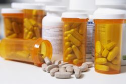 Bottles of pills, one spilling, close-up