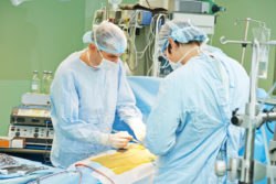Team of surgeon in uniform perform heart transplantation operation on a patient at cardiac surgery clinic