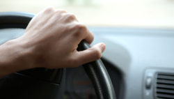 Close-up of a male hand on steering wheel