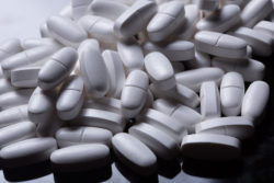 long white pills on black background close-up