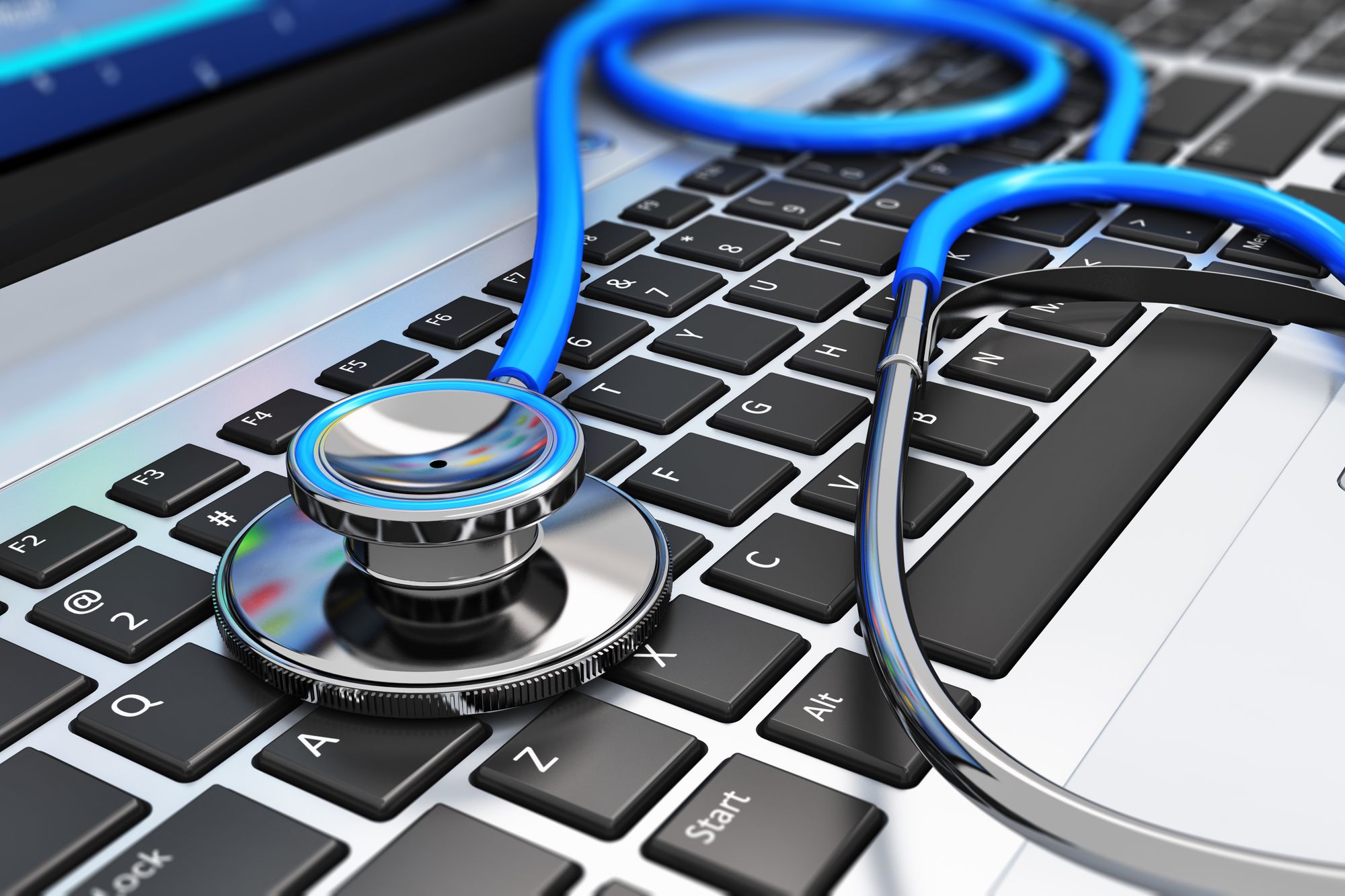 Healthcare and medicine or computer antivirus protection and repair maintenance service concept: macro view of blue stethoscope on business office laptop notebook keyboard with selective focus effect