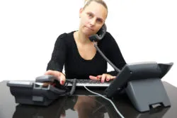 secretary in office with two phones