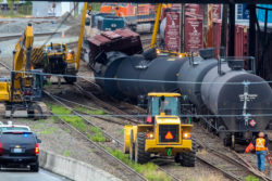 Seattle, USA - July 24, 2014: Workers mobilze to repair train tracks after several oil tank cars and one box car derailed underneath the Magnolia Bridge.