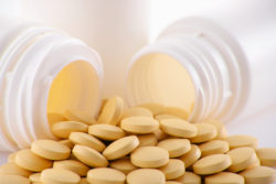 Composition with variety of drug pills and container.