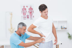 Doctor examining his patient back in medical office